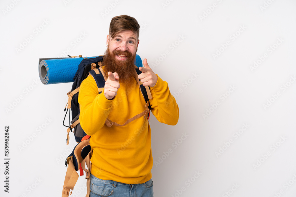 Young mountaineer man with a big backpack over isolated white background points finger at you Young mountaineer man with a big backpack over isolated white background points finger at you