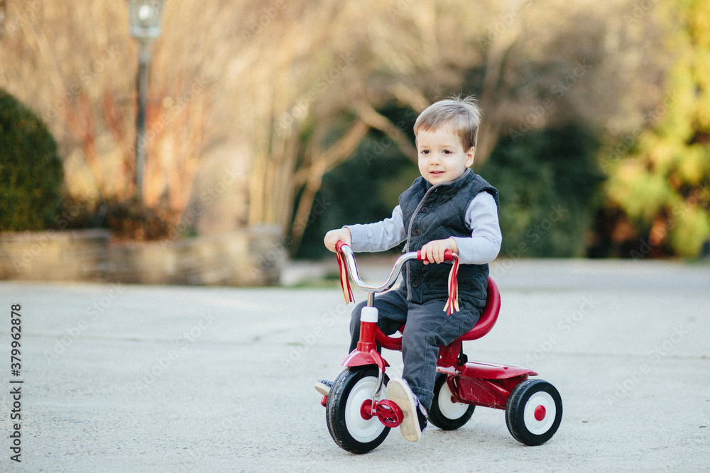 Cute young boy riding on a tricycle outside Cute young boy riding on a tricycle outside