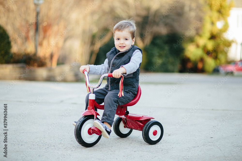 Cute young boy riding on a tricycle outside Cute young boy riding on a tricycle outside
