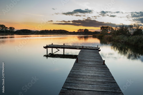 Wooden pier on a calm lake  view after sunset