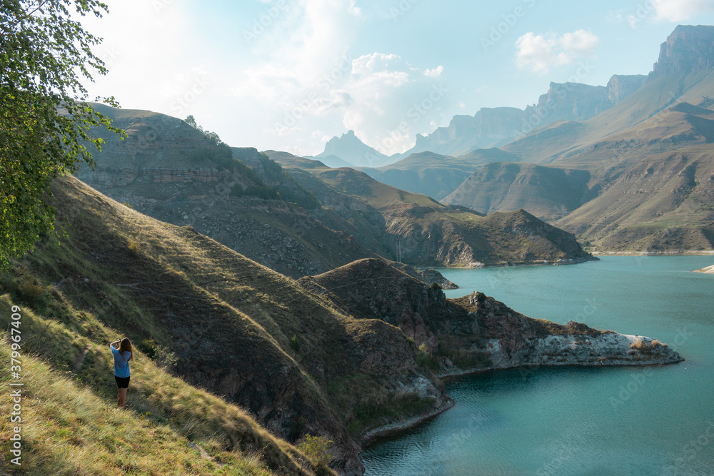 The woman is enjoying the beautiful lake view in the Elbrus region