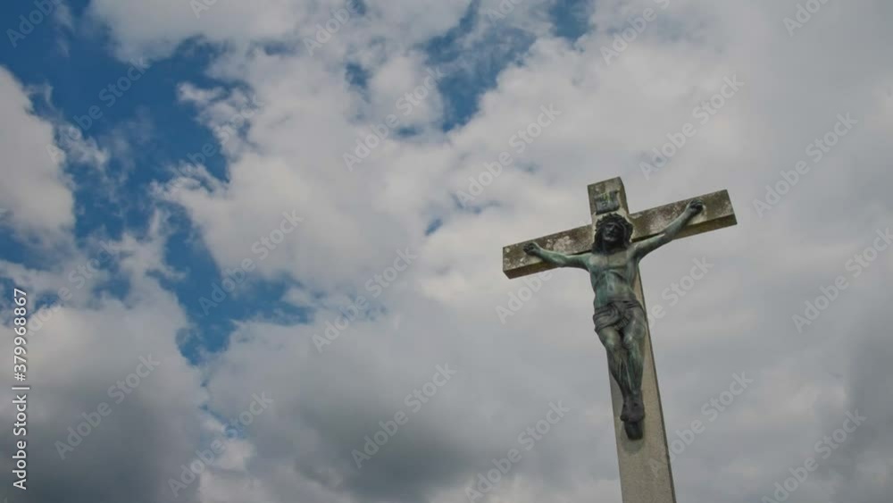 Jesus Christ on the cross against cloudy blue sky timelapse Jesus Christ on the cross against cloudy blue sky timelapse