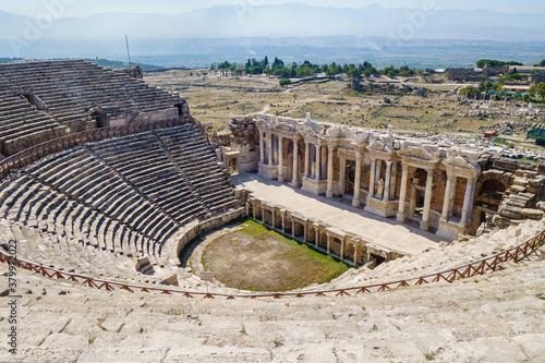 Antique theater in Hierapolis, ancient city near Pamukkale, Turkey. Scene decorated in classic style with pillars, statues, portico. Building is empty. It's included in UNESCO World Heritage List