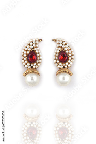Beautiful pair of earrings pearl with red gemstone on a white background. Luxury female jewelry, Indian traditional jewellery, ,Bridal Gold earrings wedding jewellery