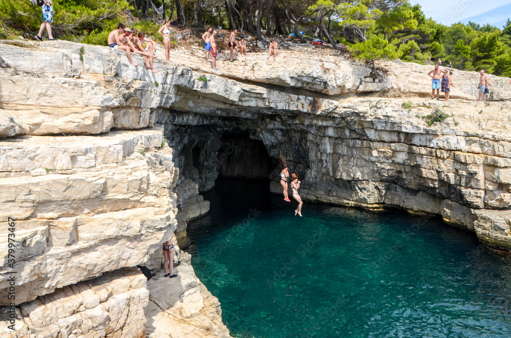 Foto Stock Girls jumps into the water. Swimmer jumping to sea from the