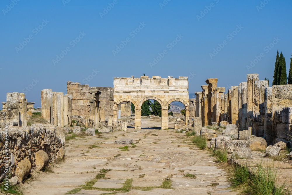 Frontinus gate on one of main streets of antique city Hierapolis, Pamukkale, Turkey. Street was surround by columns, some of them are around.  All city is included in UNESCO World Heritage List