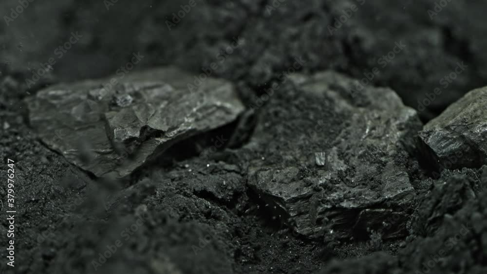 Super Slow Motion Shot of Coal Falling into Black Powder at 1000 fps.