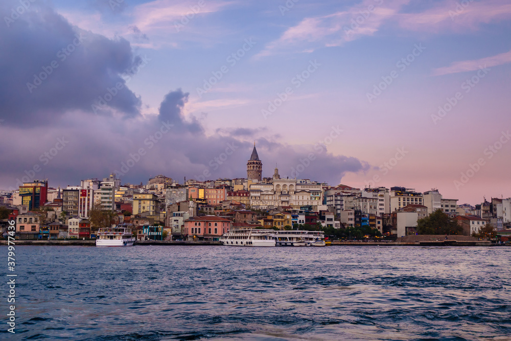Panoramic view onto Karaköy quarter of Istanbul, Turkey from Golden Horn. There are Galata Tower, minarets of Ottoman mosques, neighbourship of old & modern buildings, tourist boats & local ferries.
