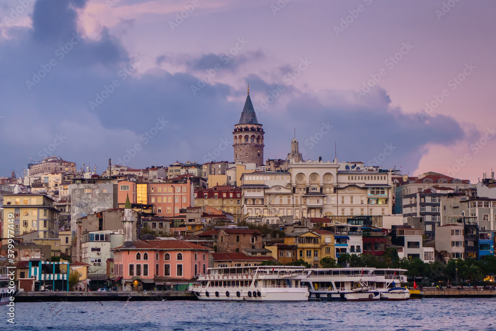 Panoramic view onto Karaköy quarter & its famous Galata Tower, Istanbul, Turkey. Also there old minaret of old mosque, neighbourship of ancient & modern buildings, tourist boats & local ferries.