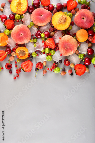 Multi-colored different fruits on a gray background. Place for text.