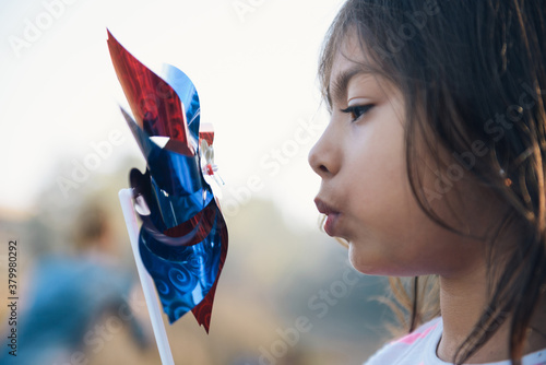 Cute little girl blowing her pinwheel photo