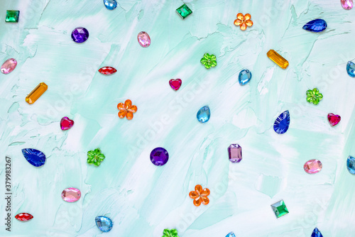 Foto Trendy plastic colorful crystal rhinestone for sewing on green abstract background