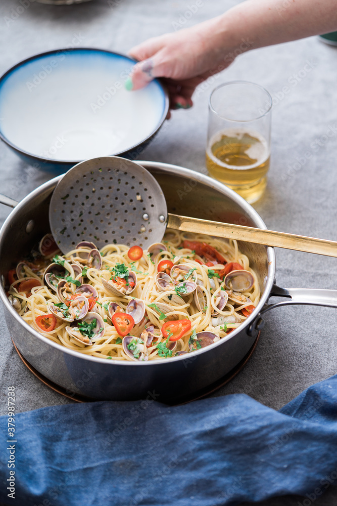 Spaghetti alle vongole being served at a table. Spaghetti alle vongole being served at a table.