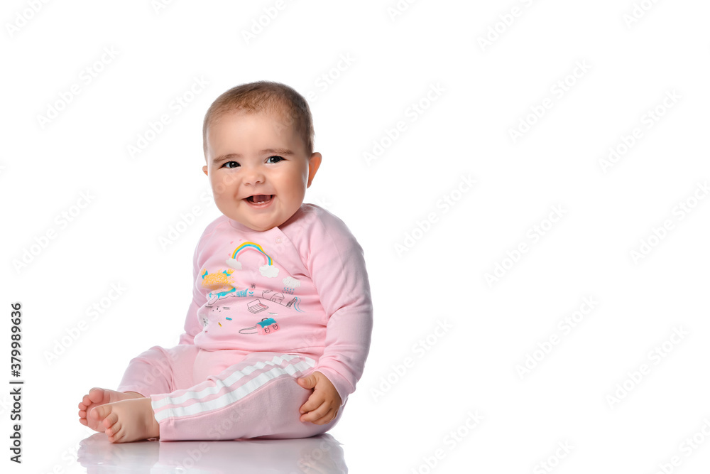 Cute little girl laughs looking at the camera on a white background.