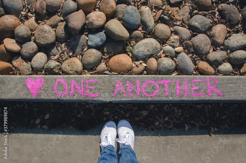 Message written on the curb saying Love one Another