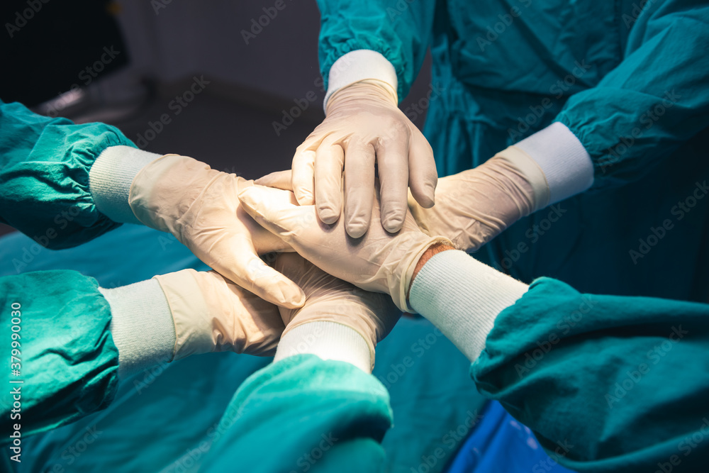 Cooperation of people in the medical community with hand together between surgeon doctor in the green suit to charity comment provide the most effective treatment to patients at Operating room. Cooperation of people in the medical community with hand together between surgeon doctor in the green suit to charity comment provide the most effective treatment to patients at Operating room.