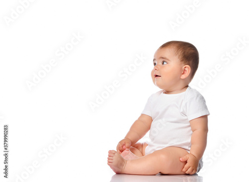 Adorable little baby smiling, sitting on the floor, studio shot, isolated on white background, lovely baby portrait