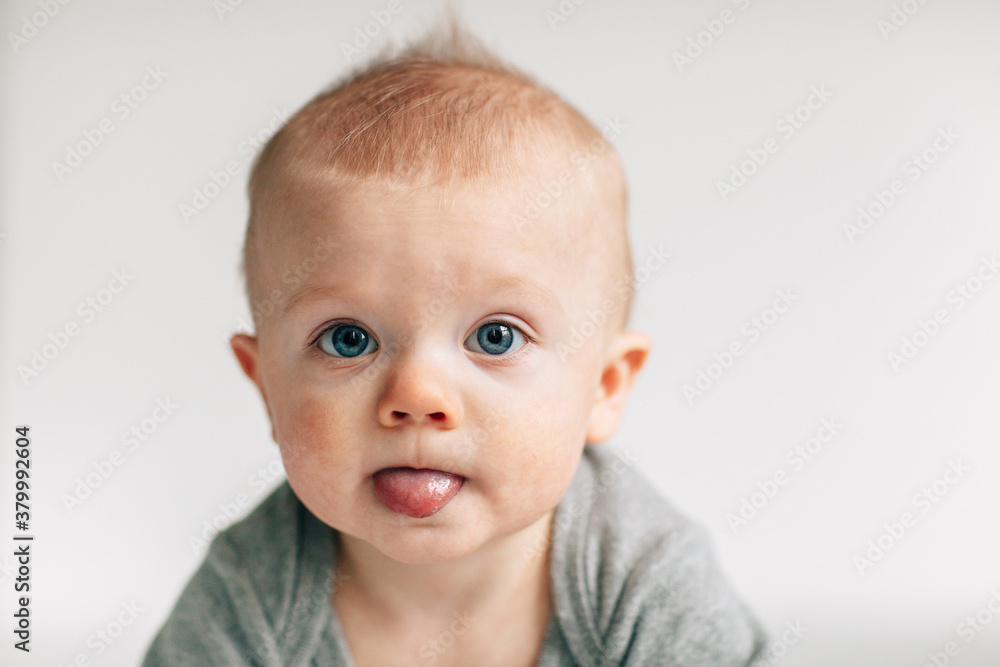 portrait of a baby poking out his tongue portrait of a baby poking out his tongue