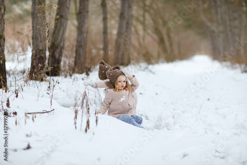 little girls play in the winter forest and make snow balls for the snowman. walking in any weather. new year vacations. happy childhood.