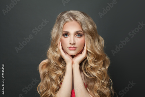 Young blonde woman with healthy curly hairstyle portrait