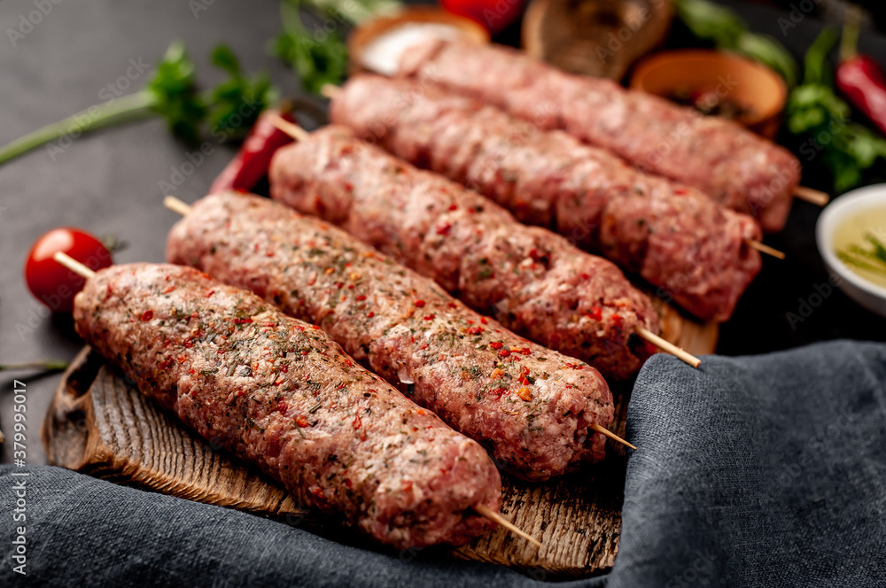 raw Lula kebab on skewers with spices on a stone background raw Lula kebab on skewers with spices on a stone background