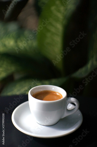 Espresso coffee in a white mug on the black table