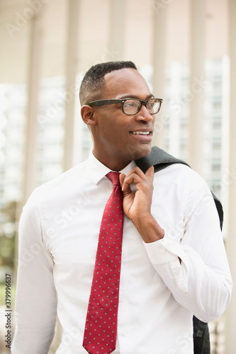 Black businessman walking on city street photo