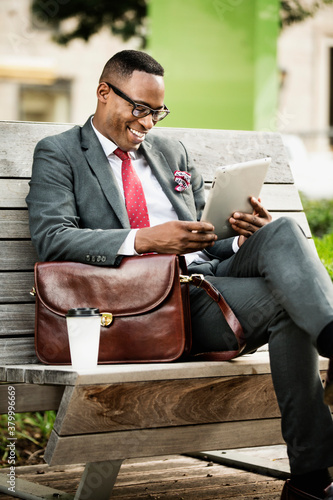 Black businessman using digital tablet outdoors photo