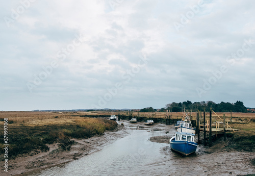 Fishing boats and salt marshes at low tide. Thornham, Norfolk, U photo