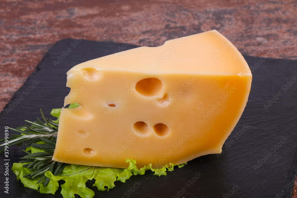 Maasdam cheese in the board served salad leaves Maasdam cheese in the board served salad leaves