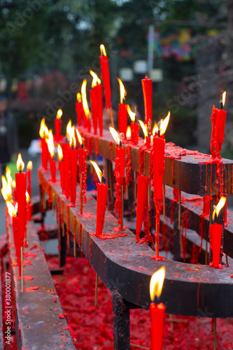 burning red candle in front of temple photo