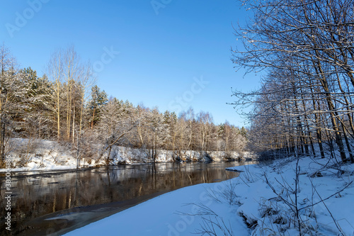 Landscape with winter forest and river. Sunrise, sunset in beautiful snowy forest.
