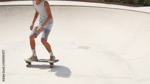 Professional skater in bowl skatepark doing tricks, skateboarder carving a turn in a deep concrete bowl, latin hispanic man on extreme surfboard, summer sports photo