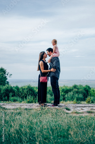 Mother and father with daughter on his neck looking at each other