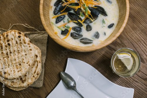 mussels with fresh vegetables and pita on wooden board from abov photo