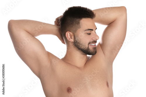 Young man showing hairless armpits after epilation procedure on white background