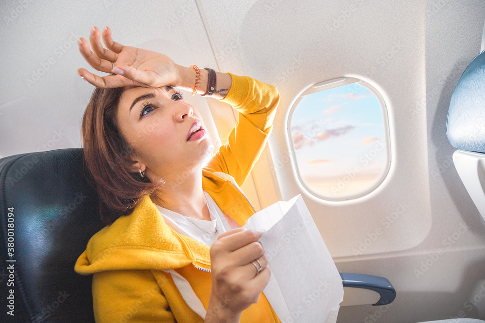 Φωτογραφία An Asian female traveler suffers from an acute attack of nausea during turbulence on a plane
