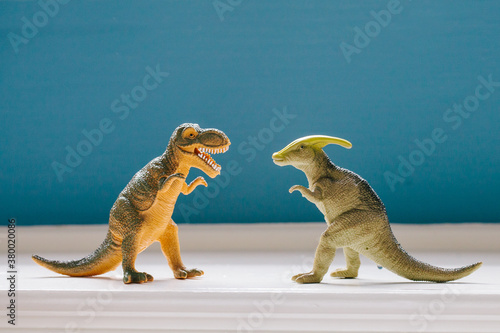 two dinosaurs facing off on a toy shelf photo