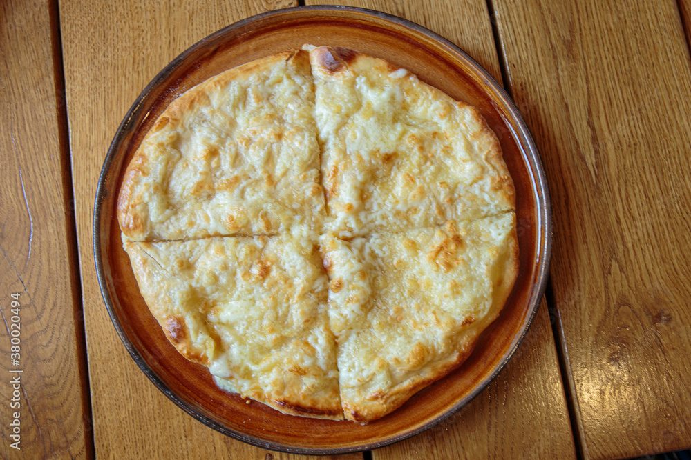 Fresh cheese pizza on a plate on the table, Italian traditional appetizer, high angle view. Fresh cheese pizza on a plate on the table, Italian traditional appetizer, high angle view.