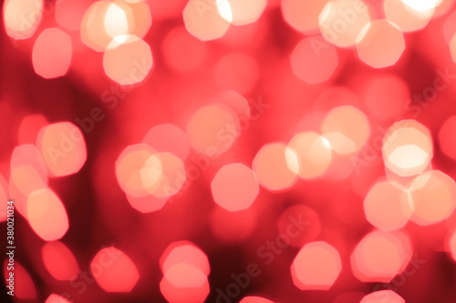 Christmas and Happy New Year on blurred red bokeh on black background, glowing sparks, holiday lights, valentine's day, place for text