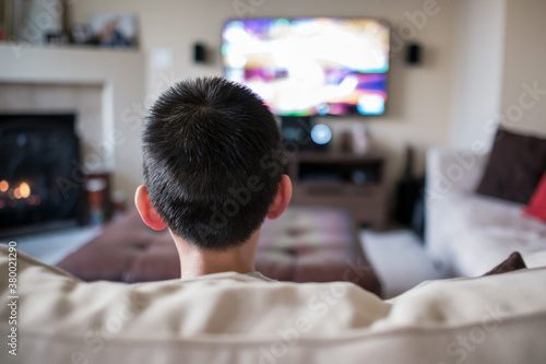 Asian kid playing video game at home photo