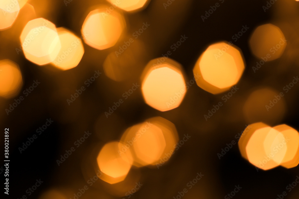 Christmas and Happy New Year on blurred bokeh of gold color on black background, glowing sparks, holiday lights, place for text Christmas and Happy New Year on blurred bokeh of gold color on black background, glowing sparks, holiday lights, place for text