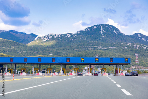 Cars passing on toll road. Point of payment on highway. Beautiful mountain landscape on background. Bitoraj mountains, Gorski Kotar, Croatia. Space for text