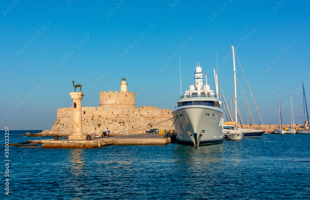 Fort of St. Nicholas and column with deer statue in Mandraki harbor of Rhodes, Greece