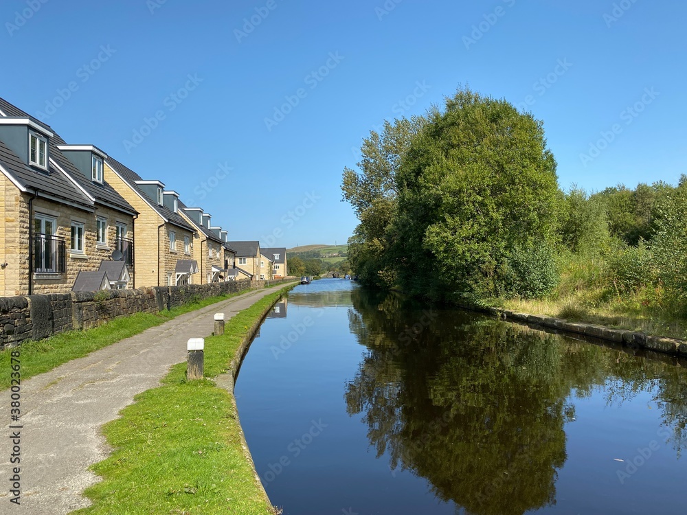 Looking along the Rochdale Canal, with a footpath, new housing, and a vivid blue sky near, Stubley, Rochdale, UK Looking along the Rochdale Canal, with a footpath, new housing, and a vivid blue sky near, Stubley, Rochdale, UK