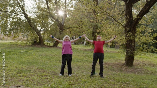 Active senior couple doing morning stretching physical exercises in park. Fitness family leisure © Andrii Iemelianenko