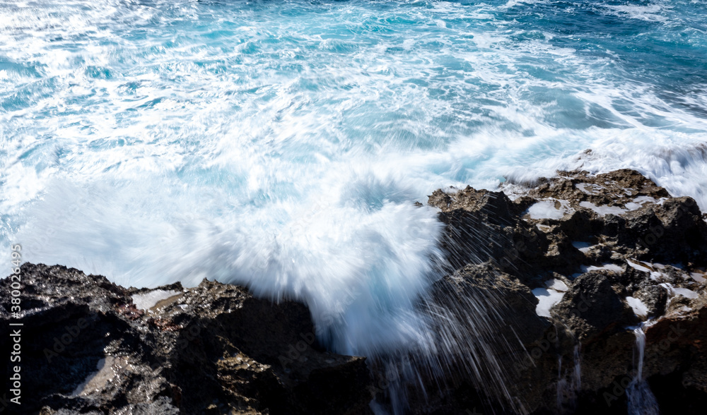 Fototapeta premium Waves crash on the rocky shore of the Mediterranean Sea on the Akamas Peninsula in the northwest of the island of Cyprus.