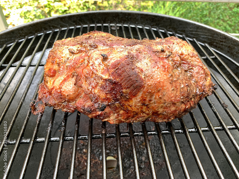 A large piece of roast pork on the grill A large piece of roast pork on the grill