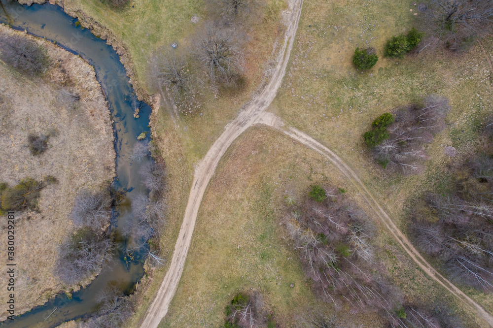 Drone shot flying on spring river in forest