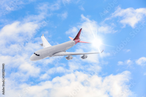 Airplane flying in blue sky with clouds. Air transportation